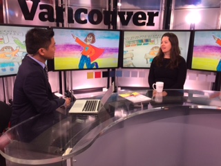 Myself sitting with a news anchor in a news studio with the picture of the Stuttering Adventures children's book on a large screen